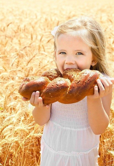blonde girl wheat field eating bread