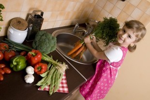 little girl washing vegetables
