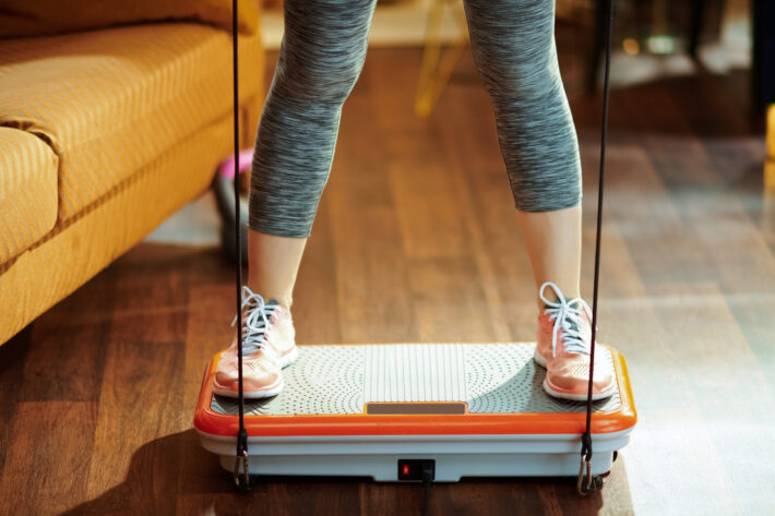 closeup of a woman's legs, standing on a vibration plate